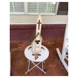 Small metal table with a wooden birdhouse.  The birdhouse is 8” x 7” x 23”