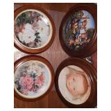 Four framed collector plates. MJ Hummel 'Apple Tree Boy And Girl', The Doll Collection limited edition baby doll 'ByeLo' by Mildred Seeley and two framed floral plates