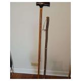 Metal adjustable walking cane 29.5-38.5 in and a walking stick similar to a shillelagh 34 in tall.