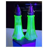 1930s Anchor Hocking Princess green depression glass salt and pepper shakers featuring a tapered, paneled silhouette and original metal screw-on lids. GLOWS under blacklight.