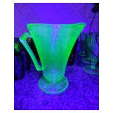 Green uranium glass footed pitcher in the Florentine No. 2 (Poppy) pattern, manufactured by the Hazel-Atlas Glass Company around 1935. Chip as shown.