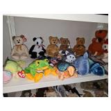 Shelf of TY beanie babies with tush tags and hang tags and three miscellaneous figures.