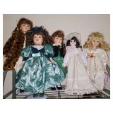 Shelf of porcelain dolls on stands.