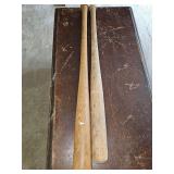 Two vintage wood bats. One is Spalding, one is Louisville Slugger.