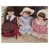 Three sitting porcelain dolls.
