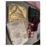 Two Christmas tablecloths with two salt and pepper shakers. The plaid has six napkins the gold has four placemats.
