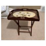 19 1/2” x 12” Butler’s tray with needlepoint cotton design. This tray is sitting on a collapsible rack 14 1/2 inches wide by 21 inches tall.