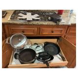 Drawer of pots and pans with a stock pot and two cast-iron skillets. 12 inch double handle lodge and a 8 inch SK.