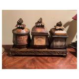 Faux antique kitchen 3 piece Canister set on a display stand. 18 inches wide stands 12 inches.