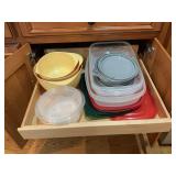 Plasticware containers and a set of yellow mixing bowls