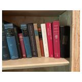 Assortment of books on two shelves and a stack of books