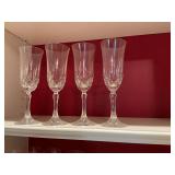 Set of four crystal champagne flutes. There is a chip on the base of one.