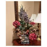 Vintage oriental blue and white pot on stand with faux flower arrangement. The pot and stand is 9” x 9”. The arrangement is approximately 26” x 36”.