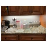 Grouping of plastic and glassware. Four pieces on the far left are plastic. The coffee products and canisters not included.