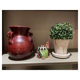 Three pieces of home decor; an 8 inch pottery vase, a porcelain dog pot and a 9 inch pottery vase with greenery