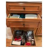 Group of miscellaneous items in drawers. Several loaf pans,grinders, juicers, KitchenAid mixer, microwaveable cooking supplies