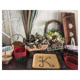 Lots of home decor items, baskets, and faux floral arrangements including wooden wall shelf