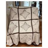 Handcrafted crochet afghan featuring classic off-white or cream motifs with a prominent central pineapple lace design