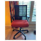 HON Ignition series mid-back work chair featuring a breathable black mesh back and a vibrant red upholstered seat cushion