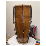 Traditional bolt-tuned wooden dholak, a two-headed Indian folk drum featuring a natural wood finish and metal tension hardware - 9”D x 18” tall