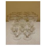 Set of (11) vintage crystal stemware features a clear flared bowl accented with a delicate gold rim on a faceted stem - includes quilted storage box