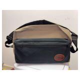 Offshore Angler fishing tackle shoulder bag featuring a black canvas body with a tan top flap