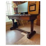 Vintage Gothic Revival-style carved oak library desk features intricate hand-carved frieze detailing and dramatic trestle support legs