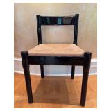 Classic Carimate chair by Vico Magistretti, featuring a bold black lacquered frame and a woven rush seat - 19-1/2 x 16-1/2 x 17-1/2 tall to seat (29-1/2 tall overall) - seat has staining