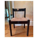 Classic Carimate chair by Vico Magistretti, featuring a bold black lacquered frame and a woven rush seat - 19-1/2 x 16-1/2 x 17-1/2 tall to seat (29-1/2 tall overall) - slight seating blemish and scra