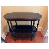 Black with gold oblong rounded two tier table. 35” x 16” x 31 1/2”.