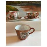 Assortment of oriental themed cups and saucers. See photos
