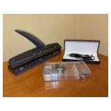 Grouping of office supplies - ACCO hole punch, clear container with paper clips, thumb tacks and binder clips, Wentur Weighted Pen (for tremors and arthritic hands