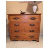 Antique four-drawer pine chest featuring distinctive hand-carved acorn and leaf motif wood pulls, metal-trimmed keyholes, and a scalloped apron