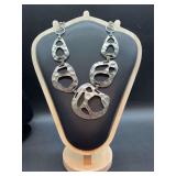 Striking silver-tone statement necklace featuring textured, asymmetrical cutout links with an organic hammered finish