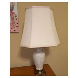 Porcelain ginger jar-style table lamp with an embossed delicate floral or weeping-branch pattern, a brass-toned square base with Asian-inspired corner accents, and a tall, tapered cream-colored fabric