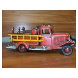 Rustic vintage-style red metal fire truck featuring a bright yellow side ladder and classic 1930s pumper truck design - 12 x 4-1/2” tall