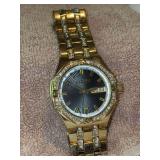 Gold-tone Elgin men's wrist watch featuring a black dial, crystal-accented bezel, and a linked metal bracelet with date display - working condition