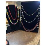 Assortment of five multicolored beaded necklaces.  The brown and pink is by Ana and the clear beaded multicolored shown is Marc Polo.