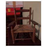 Antique doll ladder back rocking chair with rush seat. And 1/2” x 11” x 11 1/2” doll shown for chair size only.