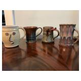 Set of four pottery coffee mugs, 3 of which are signed.
