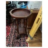 Vintage round two tier wooden side table featuring a raised Tray style top and classic turned legs and a ladies home journal tin tray they were using as an insert