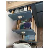 Contents of three drawers left of sink. Assortment of Storage containers, lids, and other miscellaneous.