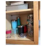 Contents of bottom shelf, left of sink of glassware and bottles