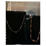 Two 22 inch beaded necklaces; multicolored and orange and brown tones