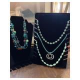 Four necklaces in blues, browns, and green tones