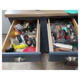 Contents of two kitchen drawers beside refrigerator.
