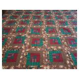 Machine stitched quilt top ready for backing, batting, and quilting. Log Cabin Block,  rich, earthy color scheme combining deep red, teal/green, and a heavily patterned floral or paisley brown border 