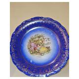 Schumann Arzberg, Bavaria Cobalt blue and gold-gilded porcelain decorative plate featuring a romantic courting couple. 11.75 in diameter.