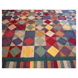 Machine stitched quilt top ready for backing, batting, and quilting. Traditional square-on-point (diamond-in-a-square) block design in a multicolored country-style aesthetic. Deep reds, mustards, navy