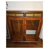 Beveled glass door cabinet with two drawers. Missing shelves. Appears to have been used as a TV cabinet, lower right back section has a cutout. 44.5 x 16 x 50.5 in tall.